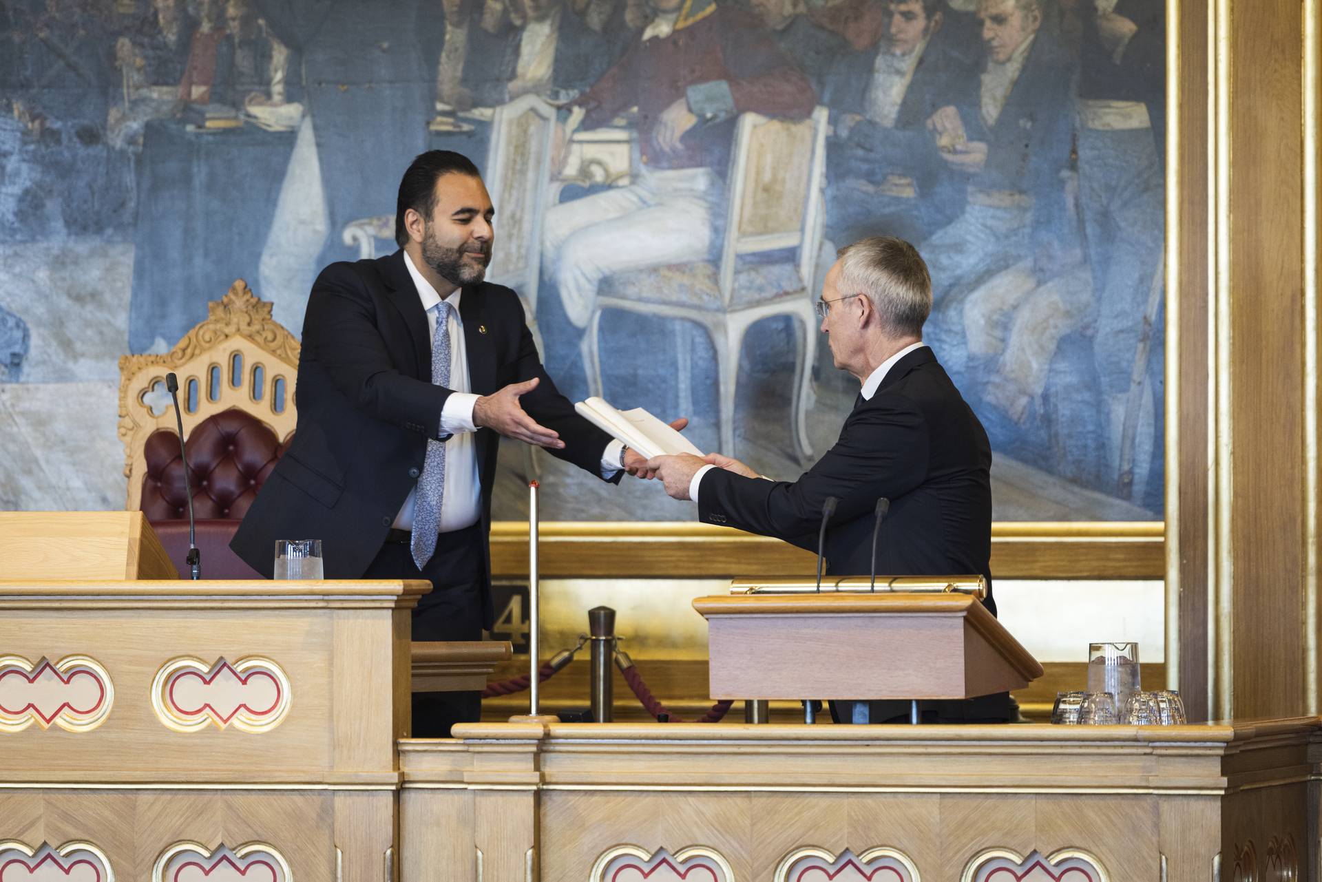 Bilde av finansministeren som overlever papirutgaven av det foreslåtte statsbudsjetttet for 2027 til stortingspresidenten