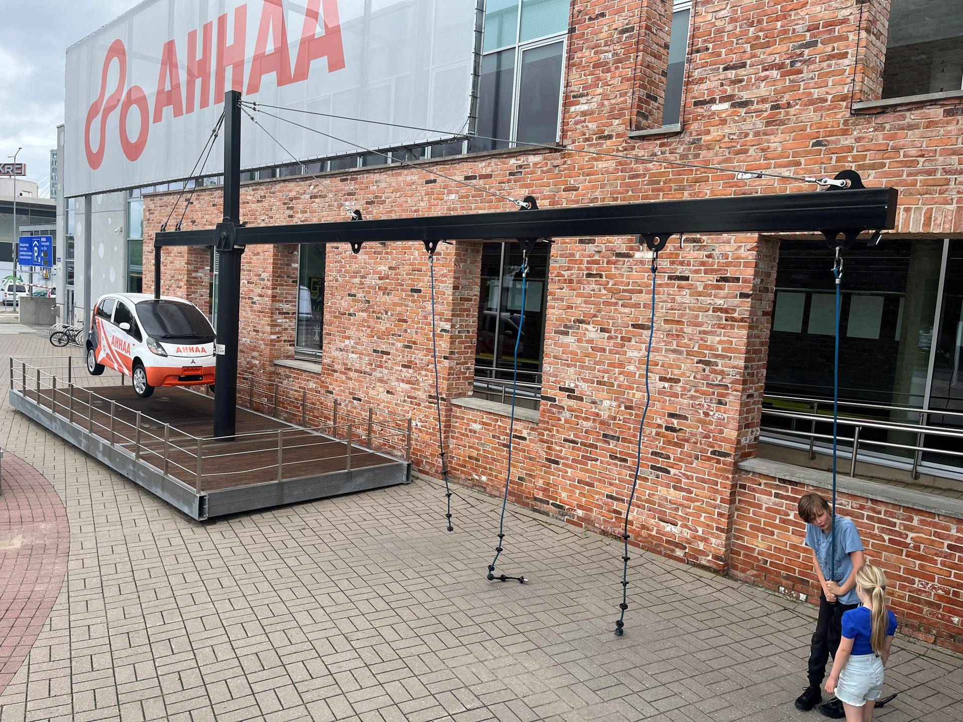 Foto av barn som løfter en liten bil ved hjelp av en vektstang