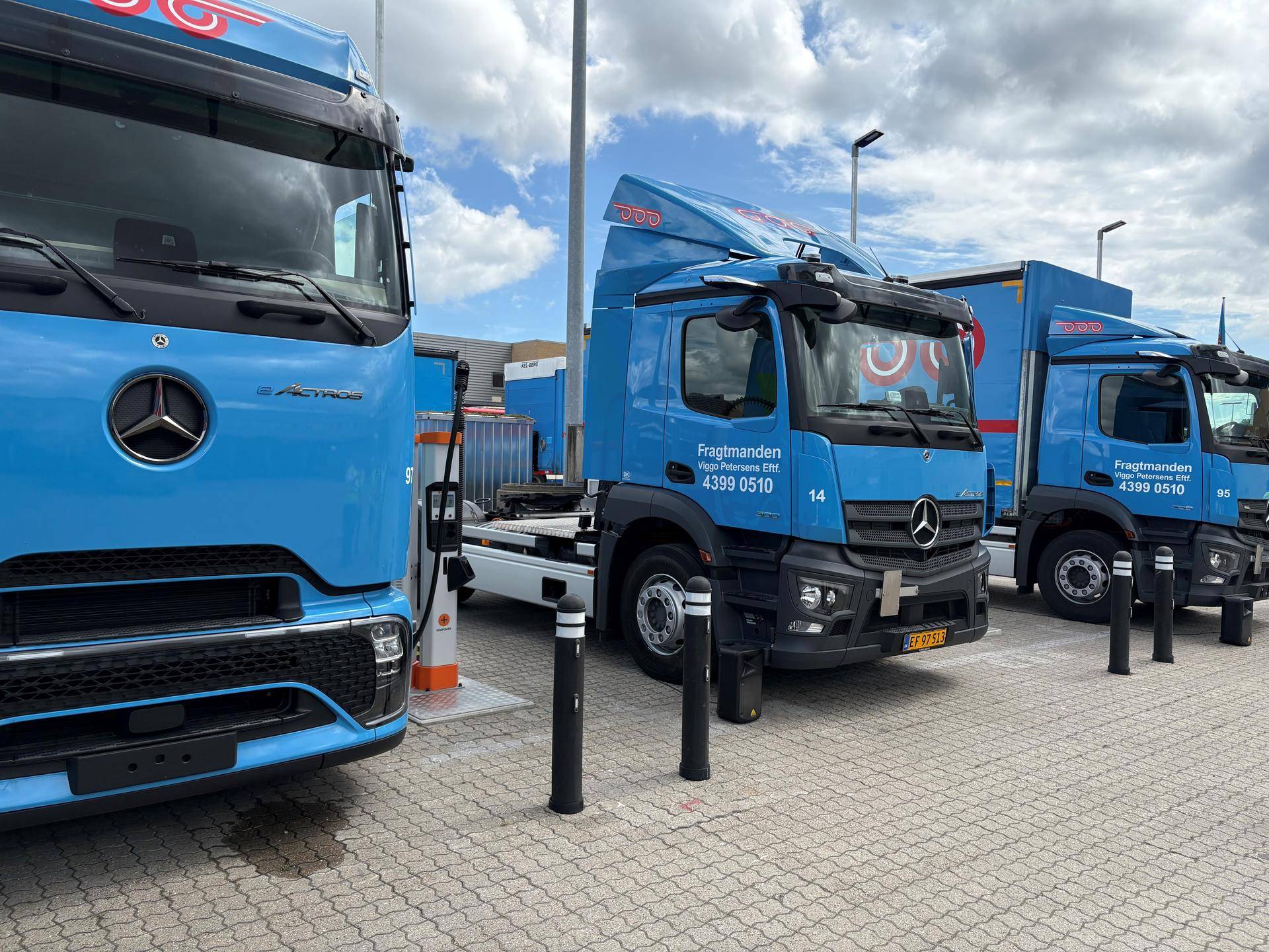 Foto av elektriske lastebiler som lades ved depoet til Danske Fragtmend utenfor København.