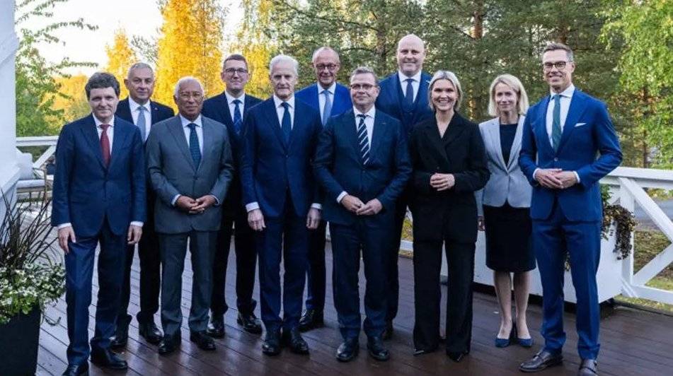 Bilde av flere toppolitikere som står sammen på en terasse ute 