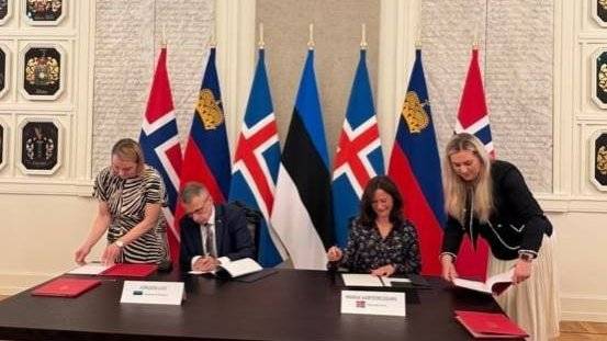 Bilde av statssekretær Varteressian som signerer avtale om EØS-midler