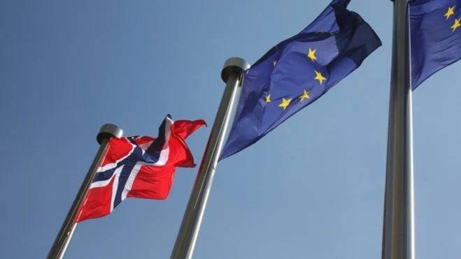 Bilde av et norsk flagg og et EU flagg som vaier i vinden